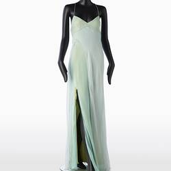 Full length pale green silk evening slip dress. Sleeveless. Flared/fishtail skirt with long slit at right.
