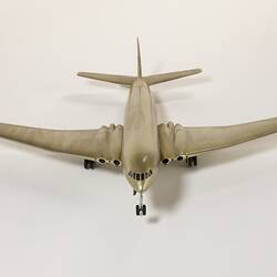 Silver model aeroplane, four wheels beneath each wing and two front wheels. British flag painted on tail.