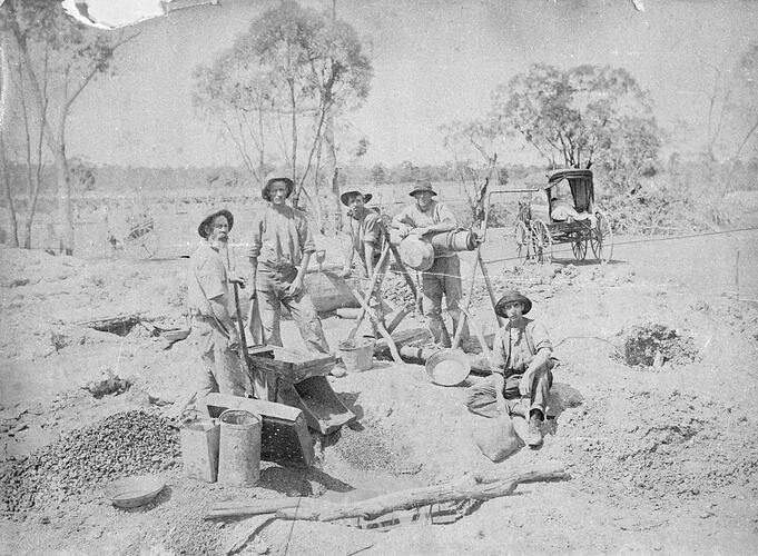 Miners with pans and cradles. Trees and horsedrawn vehicle in background.