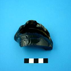 Fragment of dark green glass bottle base.