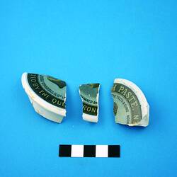 Three fragments of earthenware lid of pot.