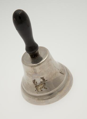 Silver bell with wooden handle.