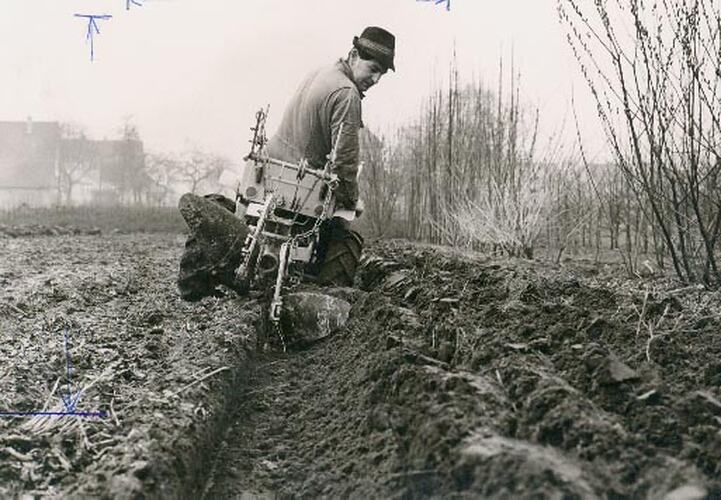 Rear of man driving a mini tractor.