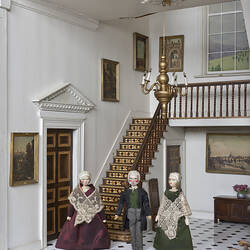 Dolls in entrance hall of dolls house.