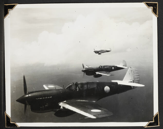 Three aeroplanes in air with land below.