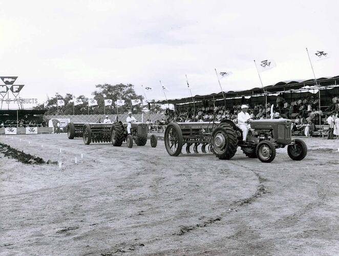 Tractors and drills on display infront of grandstand.