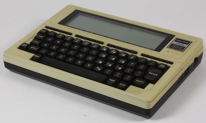 Small cream portable computer with black type keys.
