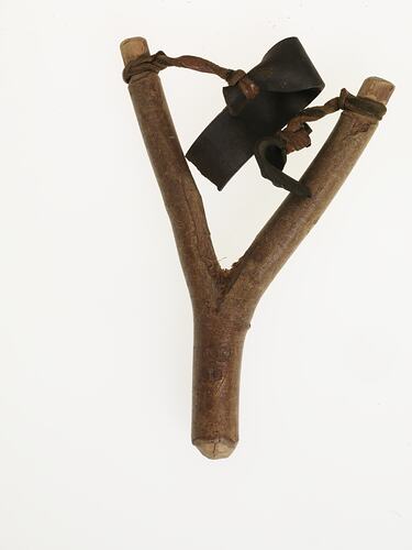 Wooden and leather slingshot, front view.