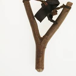 Wooden and leather slingshot, front view.