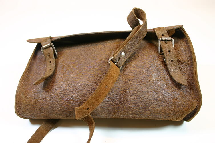 Light tan leather bag with buckle.