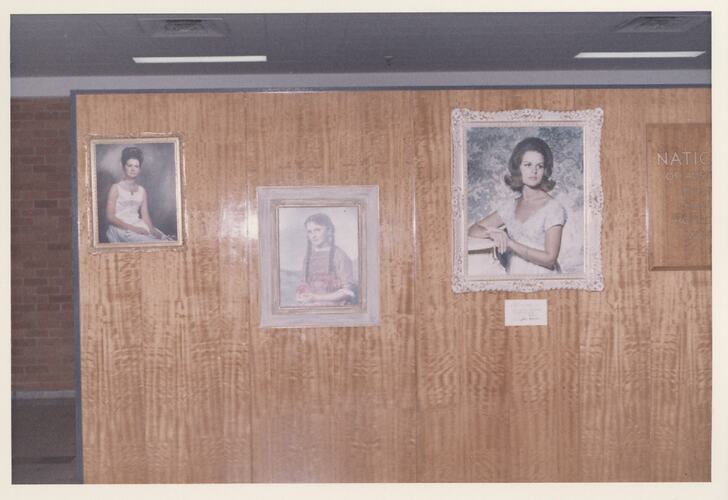 Three framed portraits of women on wall.