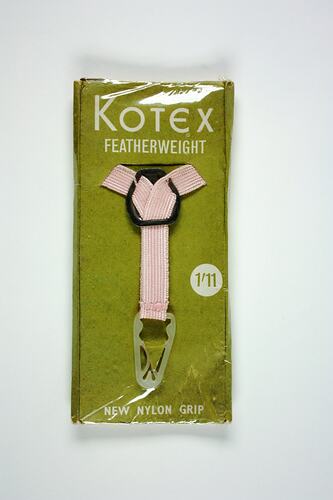 Pink y-shaped belt in plastic wrap on green card