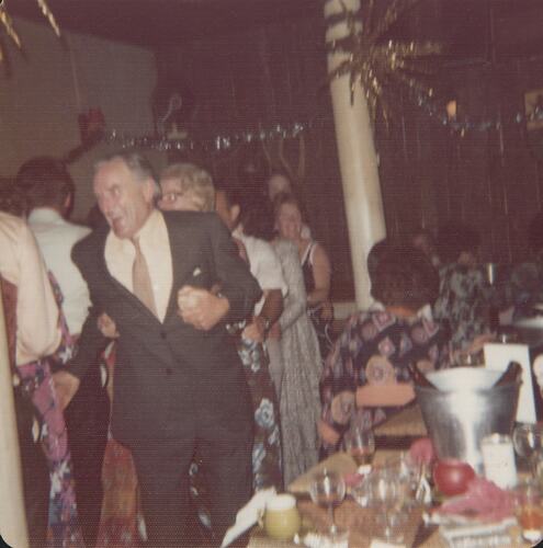 Man dancing next to table.
